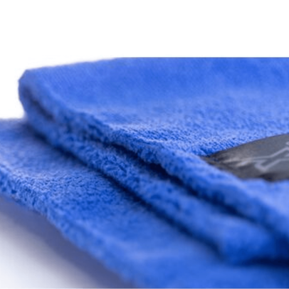 Zbliżenie na krawędź niebieskiej mikrofibry bezszwowej Xzone, miękka struktura ściereczki bez obszycia