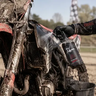 Professional cleaning of a mud-covered motocross bike using Xzone Mud Breaker preparation.